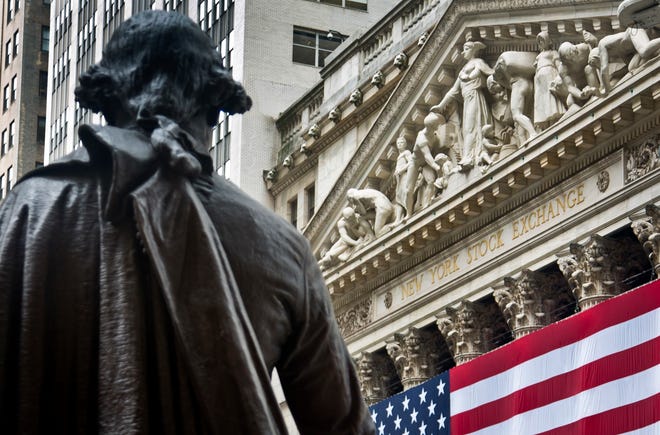 Federal Hall's George Washington statue stands near the flag-covered pillars of the New York Stock Exchange. [File Photo/The Associated Press]