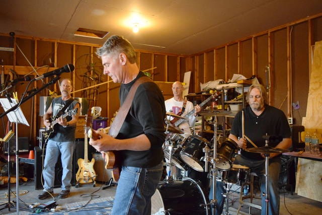 From left, Beggar’s Riddle members Mitch Rolling, Chris Delaney, Tom Dooley and Dan Poffenberger rehearse in a garage. The four Ames High graduates are reuniting for one last set of gigs after they disbanded in 1978. Photo by Dan Mika/Ames Tribune