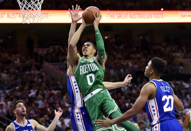 Celtics rookie Jayson Tatum (0) drives to the basket past the 76ders' Dario Saric during Friday's game in Philadelphia. [Michael Perez/AP]