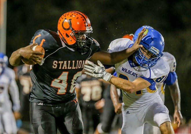Southwest's Caleb Mahone tries to elude Richlands' Kirby Carter during the first half of the Stallions' 49-0 win over the Wildcats that extended their winning streak in the series to 30 games. [John Althouse/The Daily News]