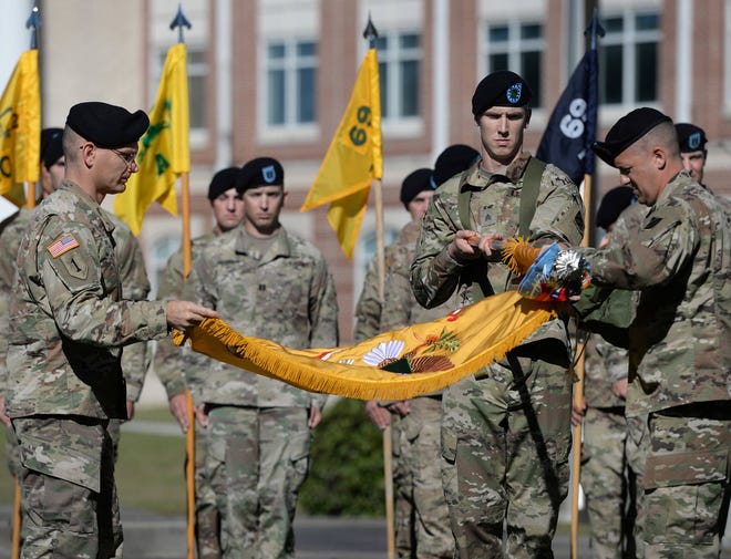 Lt. Col. Theodore Leonard, left, and Command Sgt. Maj. Jonathan Reffeor, far right, unfurl the flag of the 2nd Battalion, 69th Armored Regiment on Friday Fort Stewart during a ceremony to mark the conversion of the 2nd Brigade Combat Team of the U.S. Army’s 3rd Infantry Division into an armored brigade. (Dash Coleman/Savannah Morning News)