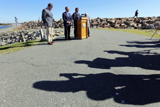 New Bedford Port Director Edward Anthes-Washburn and Mayor Jon Mitchell listen to Deepwater Offshore Wind Vice President Mathew Morrissey speak during a press event hosted at the base of the hurricane barrier near the south terminal in New Bedford. 

[ PETER PEREIRA/THE STANDARD-TIMES/SCMG ]