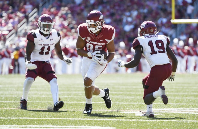 Arkansas tight end Cheyenne O'Grady tries to run the ball past New Mexico State defenders Malik Debby (left) and Austin Perkins during the first half in Fayetteville on Sept. 30. [AP Photo/Michael Woods]