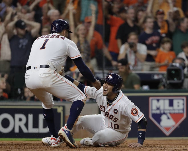 Carlos Correa and Yuli Gurriel score on a hit by Alex Bregman during the eighth inning of Game 6 against the Yankees on Friday night in Houston. The Astros won, 7-1, to send the ALCS to Game 7. [David J. Phillip/AP]