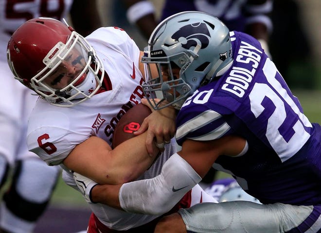 Oklahoma quarterback Baker Mayfield (6) is tackled by Kansas State defensive back Denzel Goolsby (20) during the first half of Saturday's game. [The Associated Press]