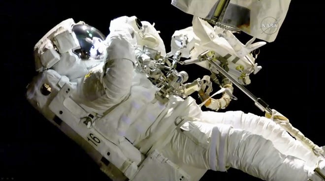 In this image from video made available by NASA, astronaut Joe Acaba performs a spacewalk outside the International Space Station on Friday. Acaba was barely outside an hour when he had to replace one of his safety tethers. Spacewalking astronauts always have more than one of these crucial lifelines in case one breaks. They also wear a jetpack in case all tethers fail and they need to fly back to the space station. (NASA via AP)