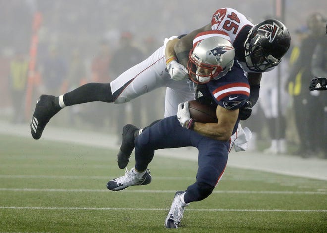 Atlanta Falcons linebacker Deion Jones (45) tackles New England Patriots wide receiver Chris Hogan (15) during the second half of their game Sunday in Foxborough, Mass. [Photo by AP]