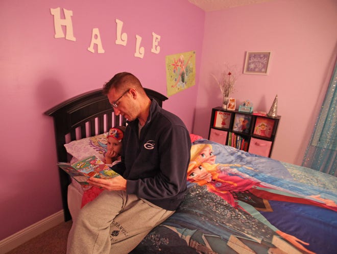 Columbus firefighter and Granville dad Mark Rine reads to his daughter Halle in her bedroom on Feb. 28, 2017. (Columbus Dispatch photo by Doral Chenoweth III)