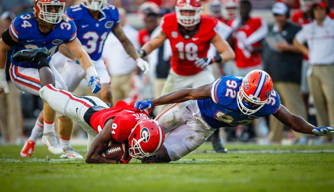 Florida defensive lineman Jabari Zuniga throws Georgia wide receiver Reggie Davis to the ground in the backfield during the second half of the Gators' 24-10 win last year at EverBank Field in Jacksonville. [File]
