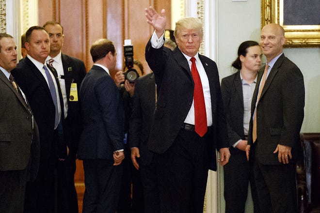 President Donald Trump waves to reporters after a lunch with Republican senator at the U.S. Capitol Tuesday in Washington. [EVAN VUCCI/ASSOCIATED PRESS]
