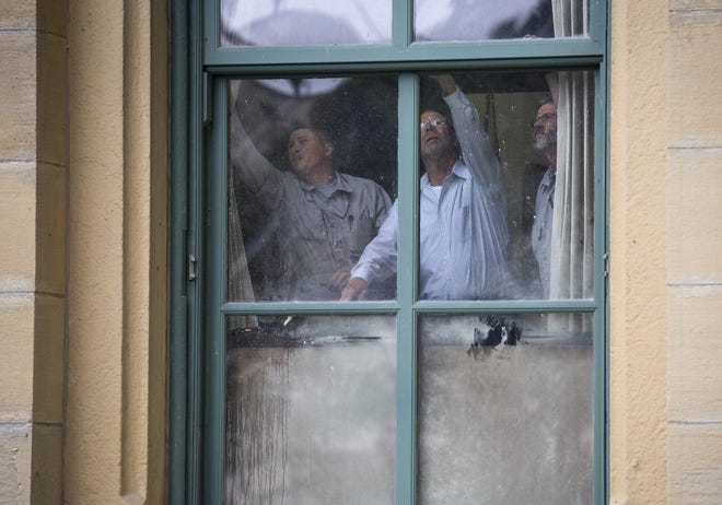 Jamie Law, left, Joe Lowder and Tom Beatty with the Secretary of State’s Physical Services Department, try to open the window in a first floor Senate office where a small fire broke out at the Capitol on Tuesday. [Rich Saal/The State Journal-Register]
