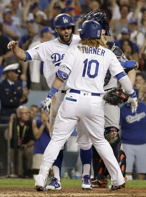 Los Angeles Dodgers' Justin Turner, right, celebrates his two-run home run with Chris Taylor against the Houston Astros during Game 1 of the World Series on Tuesday. [MATT SLOCUM/THE ASSOCIATED PRESS]