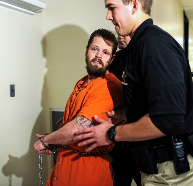 This March 19, 2015 file photo shows a police officer escorting Joseph Oberhansley through the Clark County Courthouse in Jeffersonville, Ind. A judge ruled Wednesday, Oct. 25, 2017 that Oberhansley, 36, isn't mentally competent to stand trial on charges that he killed his ex-girlfriend, 46-year-old Tammy Jo Blanton, in September 2014 and ate parts of her body. The southern Indiana judge's ruling came after she heard testimony from three doctors who evaluated him. (Tyler Stewart/News and Tribune via AP)