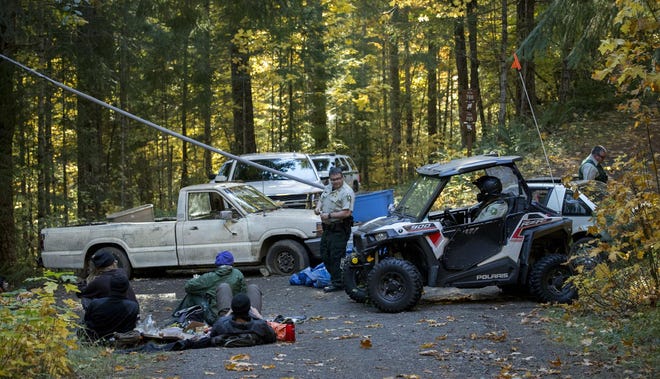 US Forest Service Law Enforcement Regional Patrol Commander Dan Smith helps guide an ATV with officers who were going to check for near a Cascadia Forest Defenders road block on Forest Road 705 that leads to the W Timber Sale within the Goose Project near McKenzie Bridge during the second full day of their action on the Willamette National Forest. (Andy Nelson/The Register-Guard)