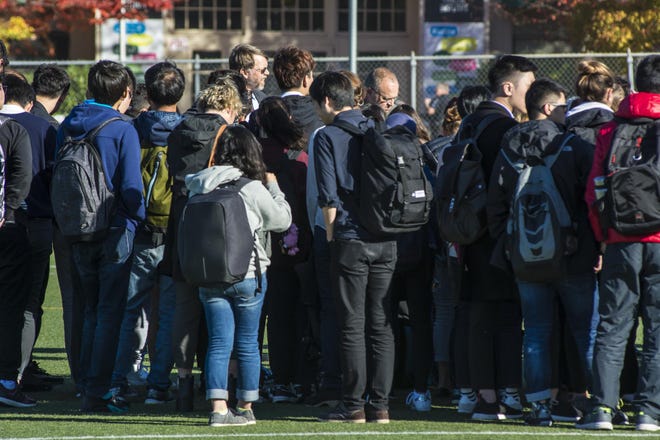 University of Oregon international students and staff listen as College of Arts and Sciences Dean Andrew Marcus explains that a bomb threat had been called in to Agate Hall, resulting in the evacuation. (Colin Houck/ for The Register Guard)
