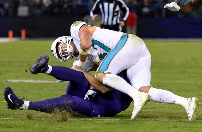 Miami Dolphins middle linebacker Kiko Alonso, top, collides with Baltimore Ravens quarterback Joe Flacco as Flacco slides on the field after rushing the ball in the first half of a game Thursday, Oct. 26, 2017 in Baltimore. (AP Photo/Nick Wass)