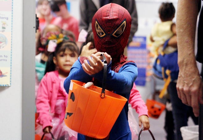 Spider-Man Luis Valasquez leads the line of preschool students through an in-school trick-or-treat adventure Oct. 31, 2013, during the Inter-Faith Day Care Halloween party. [TIMES RECORD FILE PHOTO]
