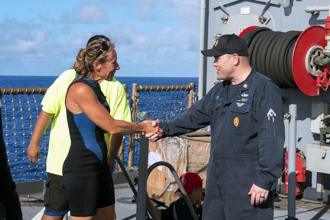 In this Wednesday, Oct. 25, 2017 photo, USS Ashland Command Master Chief Gary Wise welcomes aboard Jennifer Appel, an American mariner, one of two Honolulu women and their dogs who were rescued after being lost at sea for several months while trying to sail from Hawaii to Tahiti. The U.S. Navy rescued the women on Wednesday after a Taiwanese fishing vessel spotted them about 900 miles southeast of Japan on Tuesday and alerted the U.S. Coast Guard. The women, identified by the Navy as Jennifer Appel and Tasha Fuiaba, lost their engine in bad weather in late May, but believed they could still reach Tahiti. [Mass Communication Specialist 3rd Class Jonathan Clay/U.S. Navy via AP]