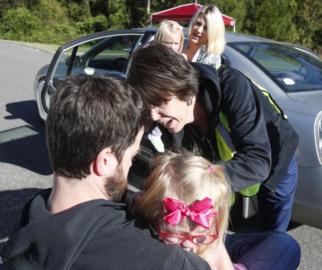 Blake McKinney holds his daughter Lily, 5, as Angie DuBose, a nurse at the Tuscaloosa County Health Department, gives her a flu shot Thursday during the drive-thru flu clinic held at the Tuscaloosa County Health Department. In the background, as McKinney's wife, Jennifer, holds their youngest daughter, Eden, 3.  [Staff Photo/Erin Nelson]
