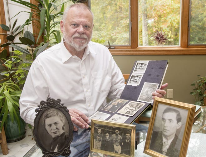 Jack Cykert looks through family photographs in his Tiverton home Thursday. the photographs left and right are his mother, Sonja Cykert, and his father, Morris Cykert, right, both circa 1950s. The center image is his uncle Samuel Cykert with his family, circa 1940, in the Lodz ghetto in Poland