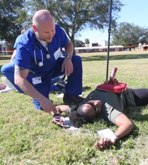 A student checks on Shundreka Allen-Jackson's injury during a mock disaster response training Friday at Gulf Coast State College. [PATTI BLAKE/THE NEWS HERALD]