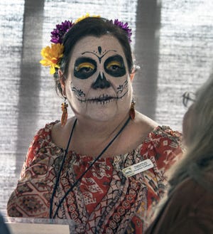 CHIEFTAIN PHOTO/JOHN JAQUES Josie Gallegos, of NeighborWorks Southern Colorado, dressed as a Dia de los Muertos character, while working a booth Friday at the Community Resource Fair, which featured safe trick-or-treating for kids.