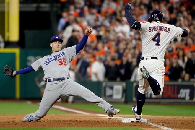 Houston Astros’ George Springer beats Los Angeles Dodgers’ Cody Bellinger to first base during the sixth inning of Game 3 of the World Series on Friday night. (AP Photo/Matt Slocum)