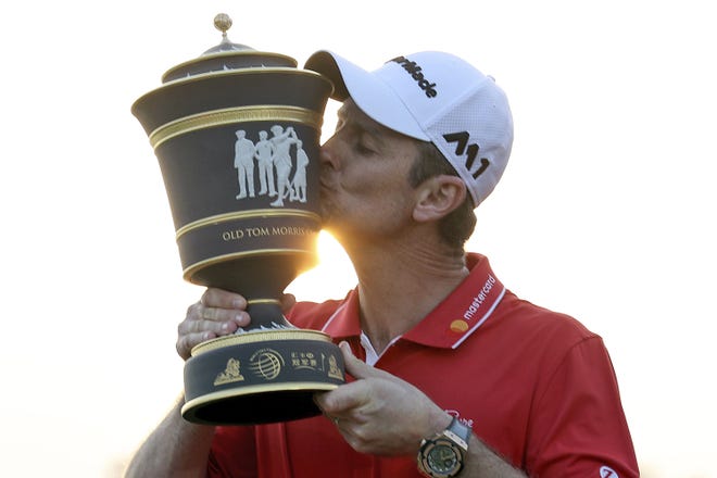 Justin Rose of England kisses the trophy after winning the 2017 WGC-HSBC Champions golf tournament held at the Sheshan International Golf Club in Shanghai, China, Sunday, Oct. 29, 2017. Rose took advantage of a record-tying collapse by Dustin Johnson and rallied from eight shots behind to win. [AP Photo/Ng Han Guan]
