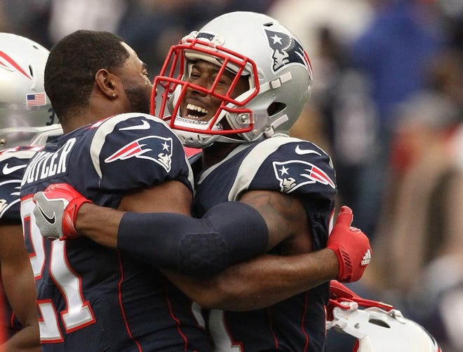 Patriots defensive back Jonathan Jones (31) celebrates with Malcolm Butler after his interception on the last play of the game to secure a 21-13 win.