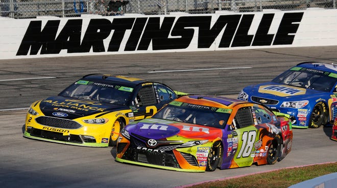 Kyle Busch (18) and Brad Keselowski (2) lead the field on a restart during the third stage of the Sunday’s race at Martinsville. (AP Photo/Steve Helber)