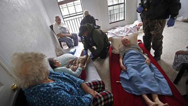 National Guard and other personnel help rescue elderly people Aug. 30 after an assisted living facility in Orange was flooded by Hurricane Harvey. Deaths at nursing home facilities in Texas and Florida after recent hurricanes made landfall have left families of residents, law enforcement officials and state regulators questioning evacuation decisions. Experts on aging say the risk of illness and death increases for elderly residents who are evacuated and advocate a patient-by-patient risk assessment system. (AP Photo/Gerald Herbert)