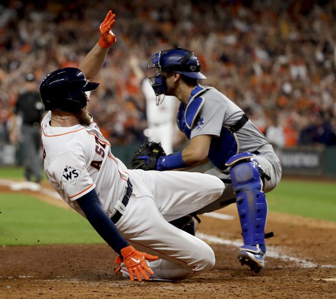 Houston's Derek Fisher beats the throw home to Dodgers catcher Austin Barnes and scores the game-winning run in the 10th inning of Game 5. [Matt Slocum/AP]