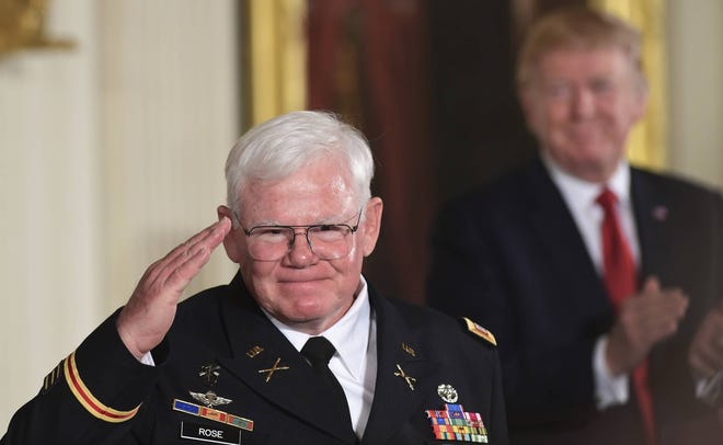 President Donald Trump, right, watches as retired Army Capt. Gary M. Rose, left, salutes before receiving the nation’s highest military honor, the Medal of Honor, during a ceremony in the East Room of the White House in Washington, Monday, Oct. 23, 2017. (AP Photo/Susan Walsh)