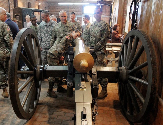 Colonel Vivian Caruolo, of the RI National Guard, takes a close look at one of the Civil War era cannons unveiled at the Governor Sprague Mansion in Cranston Tuesday morning.[The Providence Journal/Glenn Osmundson]
