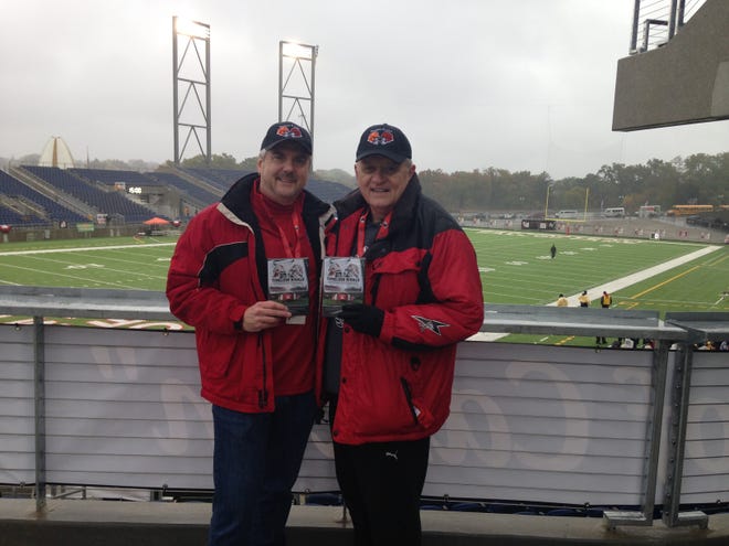 Director Dave Jingo and executive producer Ted Bowersox pose with copies of their "Timeless Rivals" DVD before the start of Saturday's McKinley-Massillon game at Paul Brown Tiger Stadium. (Joe Scalzo | The Repository)