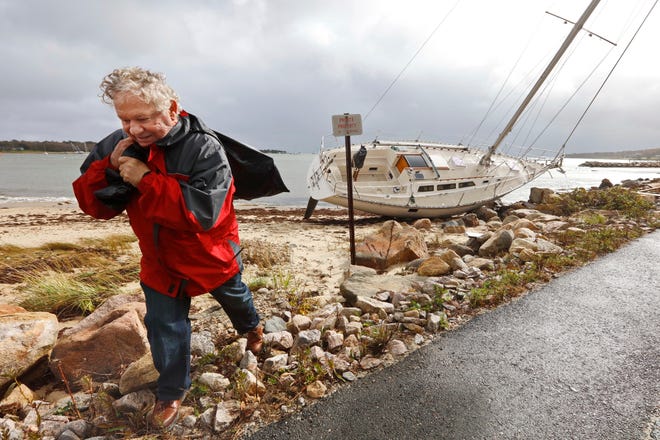 Jack Durant, owner of the sailboat Lionheart, carries a bag with valuables he removed from his sailboat after it washed up on shore after overnight high winds sent saiboats crashing onto Padanaram beach in Dartmouth. 

[ PETER PEREIRA/THE STANDARD-TIMES/SCMG]