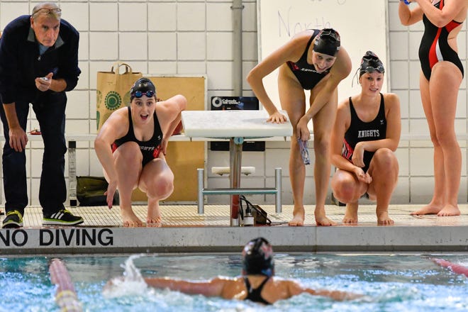 North Andover swimmers cheer on teammate Caroline Gust as she heads towards the finish in the 100-meter butterfly against Melrose at the Mystic Valley Regional Charter School on Oct. 23. [Wicked Local Staff Photo / David Sokol]