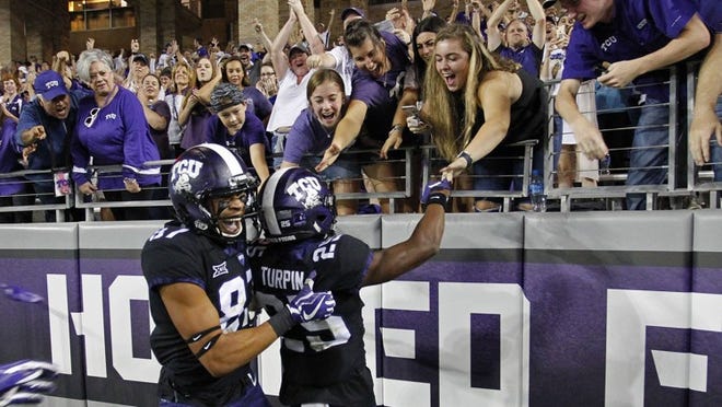 Texas Christian wide receivers KaVontae Turpin (25) and TreVontae Hights (87) celebrate in the end zone after Turpin’s 90-yard third quarter touchdown punt return against Kansas at Amon G. Carter Stadium in Fort Worth, Texas, on Saturday. CREDIT: Paul Moseley/Fort Worth Star-Telegram