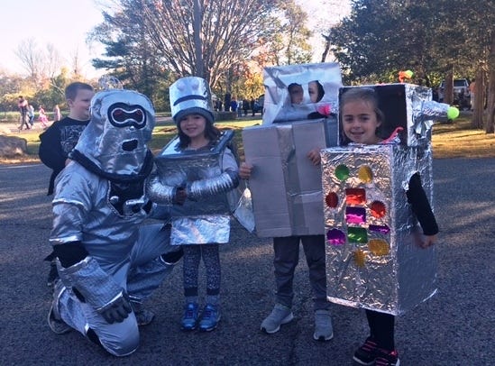 P.E. teacher C.J. Patota with kindergarteners Emma Zizza, Nathaniel Powell, and Samantha D'Antonio, all dressed up as Roz the Robot from "The Wild Robot".

[Wicked Local Photo/James Kukstis]