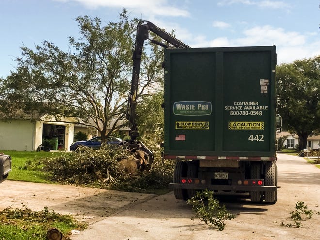 A Waste Pro "claw" truck picks up debris in Palm Coast. City Manager Jim Landon said Tuesday there are now seven trucks from two different national haulers dedicated to debris removal in the city, which should free up Waste Pro to focus on regular trash hauling. [Photo provided/City of Palm Coast]