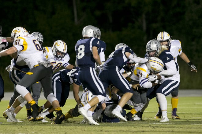 Arnold defenders converge on a Port St. Joe ball carrier last week in the Marlins' victory. [JOSHUA BOUCHER/THE NEWS HERALD]