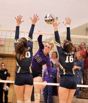Triway's Mary Cornelius (middle) spikes the ball through the hands of Beaumont's Claire Roscoe (left) and Kimmy Sweeney (16) as they go up for an assist block during their Div. II regional semifinal match Thursday night at Stow-Munroe Falls High. The Titans' season ended with a 3-0 loss to the Blue Streaks.