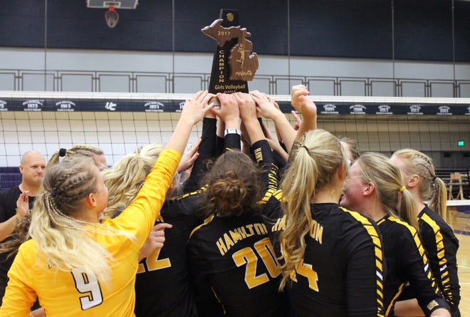 The Hamilton volleyball team surrounds the district championship trophy, its first since 2007. [Chris Zadorozny/Sentinel staff]