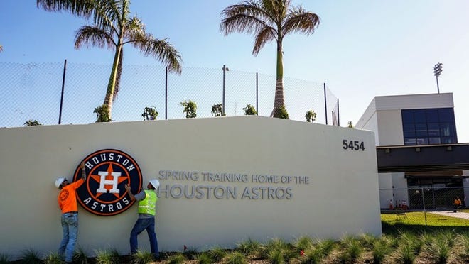 Bobby Todd, left, and Gill Strelec with Donnie Bennett Lighting, install a sign outside the Houston Astros clubhouse during the start of spring training at the Ballpark of the Palm Beaches in West Palm Beach on February 15, 2017. (Richard Graulich / The Palm Beach Post)