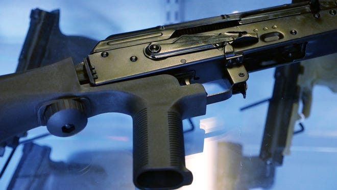 A device called a bump stock, which effectively converts semi-automatic rifles into fully automated weapons, is attached to a rifle at a gun store in Utah. [AP Photo/Rick Bowmer]