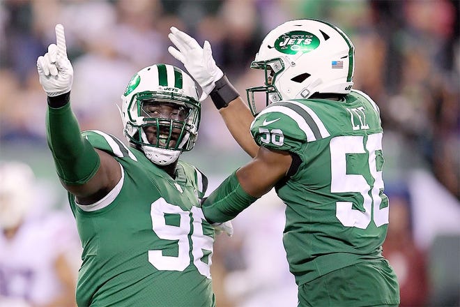 New York Jets defensive end Muhammad Wilkerson (96) and inside linebacker Darron Lee (58) celebrate after a play against the Buffalo Bills during the second half of an NFL football game Thursday in East Rutherford, N.J. [BILL KOSTROUN/ASSOCIATED PRESS]