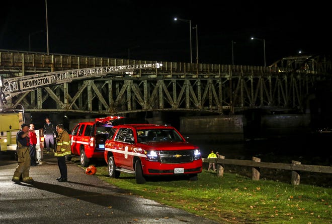 Firefighters and police from around the Seacoast rescue a women who climbed down from the General Sullivan Bridge Friday night in Dover. [Shawn St.Hilaire/Fosters.com]