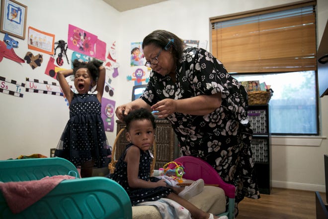Cheryl Givens-Perkins brushes her granddaughters' hair for church. Givens-Perkins cares for her three grandchildren after her daughter Cassaundra Lynn Perkins died of an infection just over a week after giving birth to her twins. She was 21. (Ilana Panich-Linsman/Los Angeles Times/TNS)