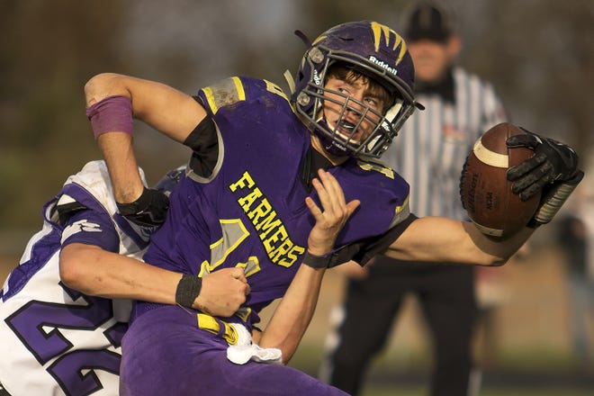 Farmington senior wide receiver Jakob Uryasz tries to spin away from a Wilmington defender after catching a pass during the Farmers' 37-12 loss to the Wildcats in the Class 3A playoff game on Saturday in Farmington. STEVE DAVIS/GATEHOUSE MEDIA ILLINOIS