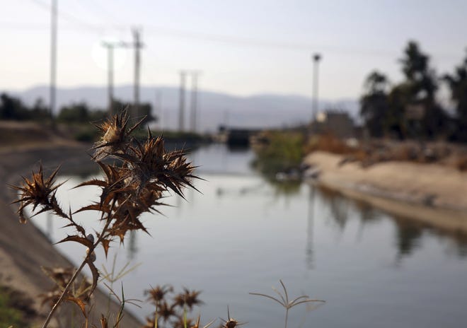A stretch of the King Abdullah Canal, the largest irrigation system near the town of Northern Shouneh, Jordan, is pictured. Recent studies say the kingdom, a Western ally and refugee host nation with a growing population, is being hit particularly hard by climate change, getting hotter and drier than previously anticipated. [OMAR AKOUR/AP]